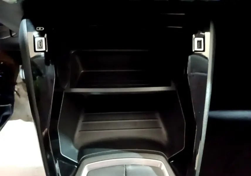 Gros plan sur la console centrale noire de la Peugeot 208 2020, avec ports USB visibles de chaque côté.