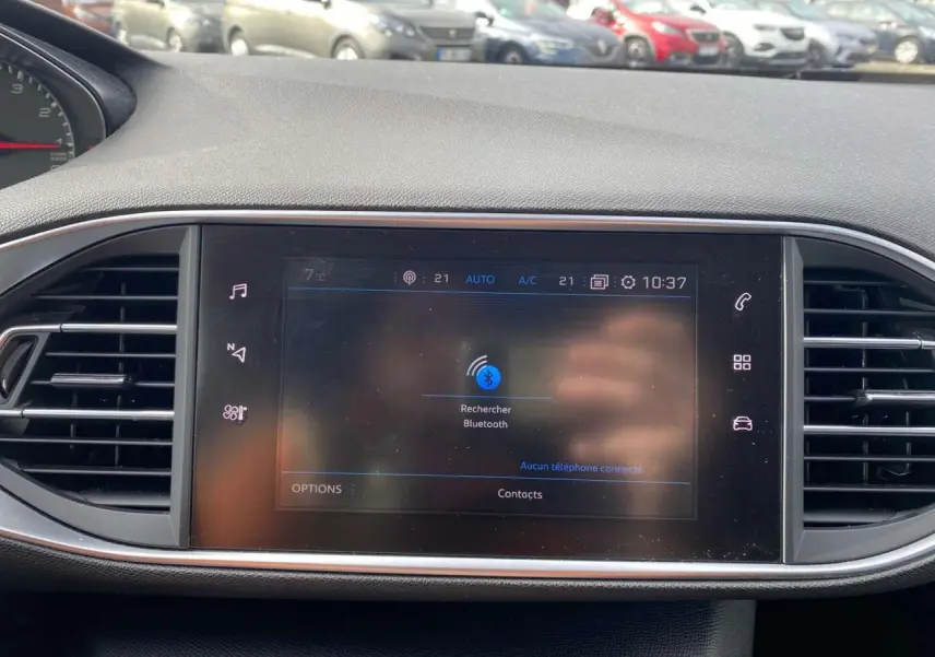 Vue rapprochée de l’écran tactile central du tableau de bord de la Peugeot 308, avec les aérateurs latéraux visibles.