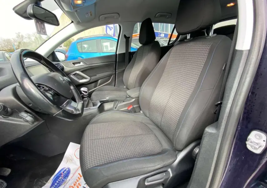 Vue intérieure côté conducteur du Peugeot 308 2018 bleu foncé, montrant les sièges avant et le volant avec boîte manuelle.