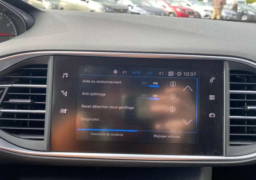 Écran tactile central de la Peugeot 308 2018 affichant les aides à la conduite, entouré de grilles d’aération noires.