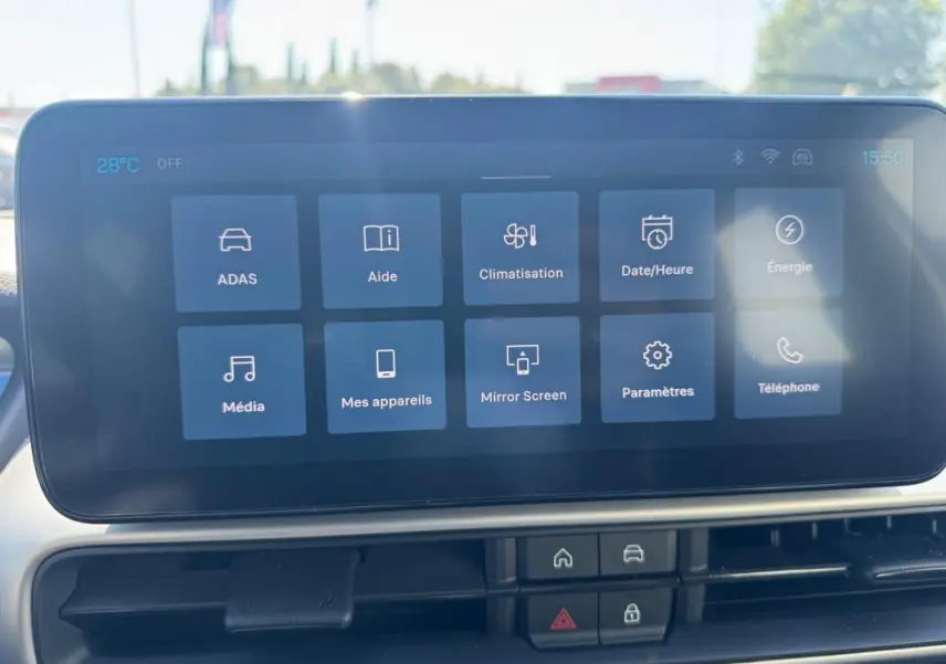 Écran tactile central du Jeep Avenger blanc 2025 montrant les options climatisation, média et paramètres.