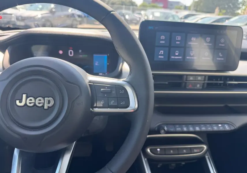 Vue intérieure centrée sur le volant cuir Jeep et l’écran tactile du tableau de bord du Jeep Avenger électrique.