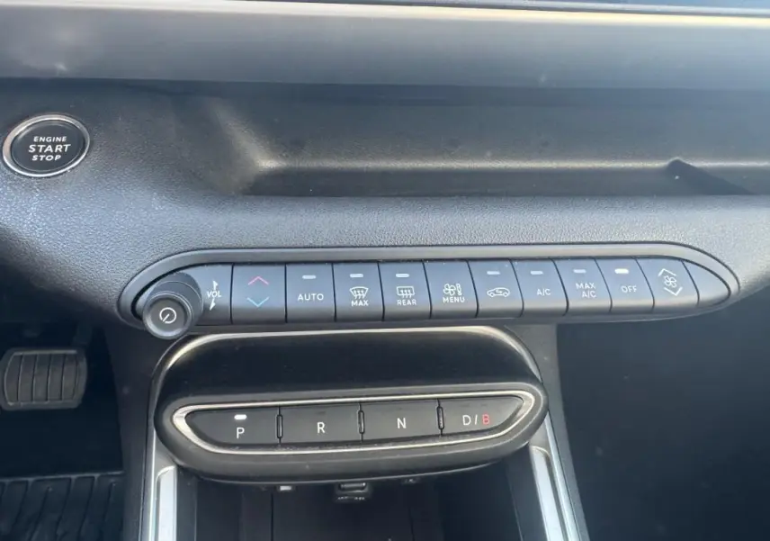 Vue rapprochée de la console centrale du Jeep Avenger électrique 2025, avec commandes climatisation et boîte auto.