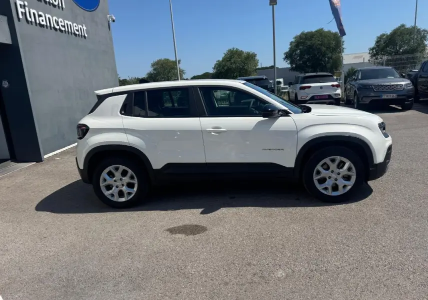 Profil latéral droit d'un Jeep Avenger électrique blanc 2025 avec jantes alliage 17 pouces et toit ouvrant en verre.