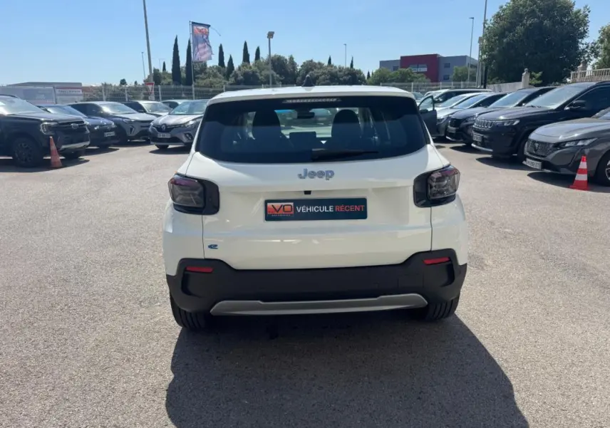 Vue arrière d'un Jeep Avenger électrique blanc 2025 avec feux arrière fumés et plaque d'immatriculation "Véhicule récent".
