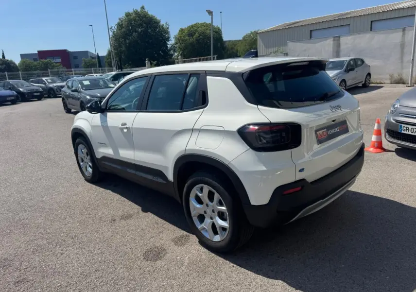 Jeep Avenger électrique blanc vu en 3/4 arrière droit, avec jantes alliage 17 pouces et toit noir contrasté.