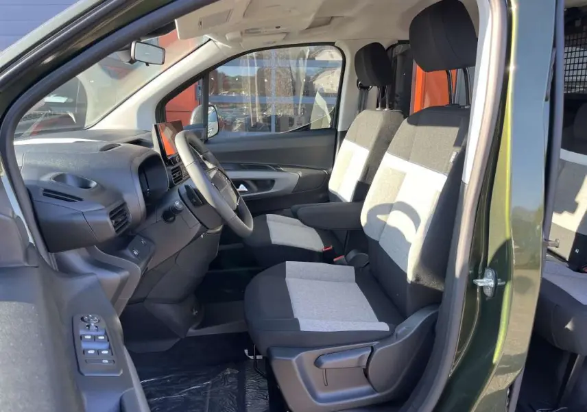 Vue intérieure côté conducteur du Citroën Berlingo 2026 Sirkka green, montrant les sièges tissu bicolores et le volant multifonctions.