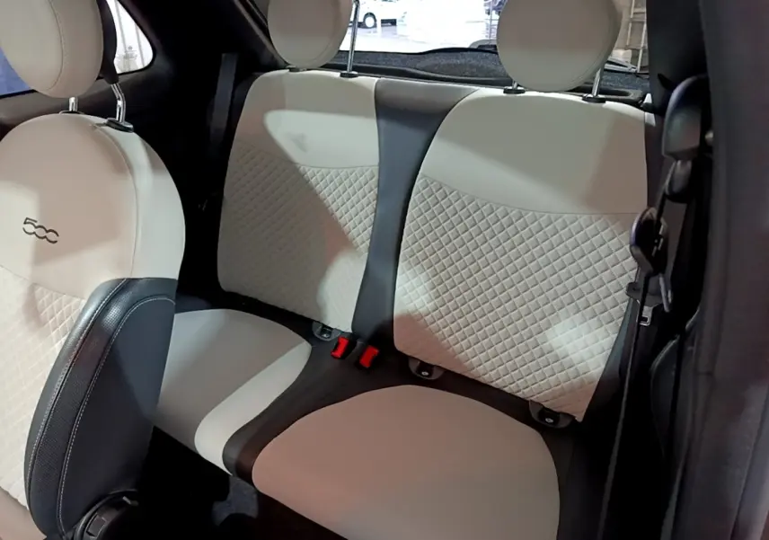 Vue intérieure montrant la banquette arrière beige et noire avec surpiqûres, et l'avant du siège conducteur de la FIAT 500.