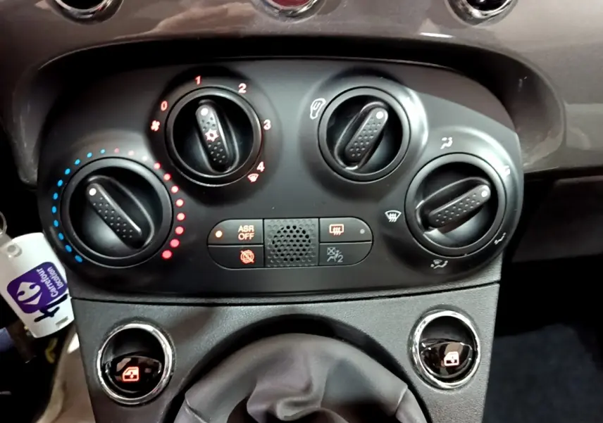 Vue rapprochée des commandes de climatisation et du levier de vitesses d'une Fiat 500 gris foncé, version 2022.