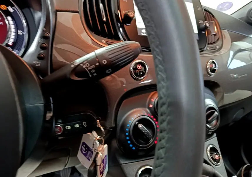 Vue rapprochée de l’intérieur gris foncé du tableau de bord et volant cuir de la Fiat 500 1.0 Dolcevita 2022.