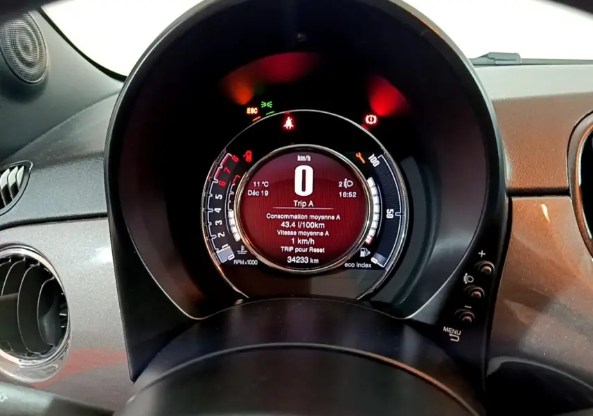 Vue rapprochée du tableau de bord numérique circulaire de la Fiat 500 gris foncé, affichant les informations de conduite.