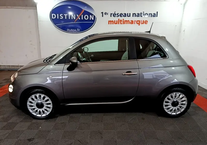 Profil droit d'une Fiat 500 gris foncé 2022, version Dolcevita, avec jantes alliage et intérieur visible.