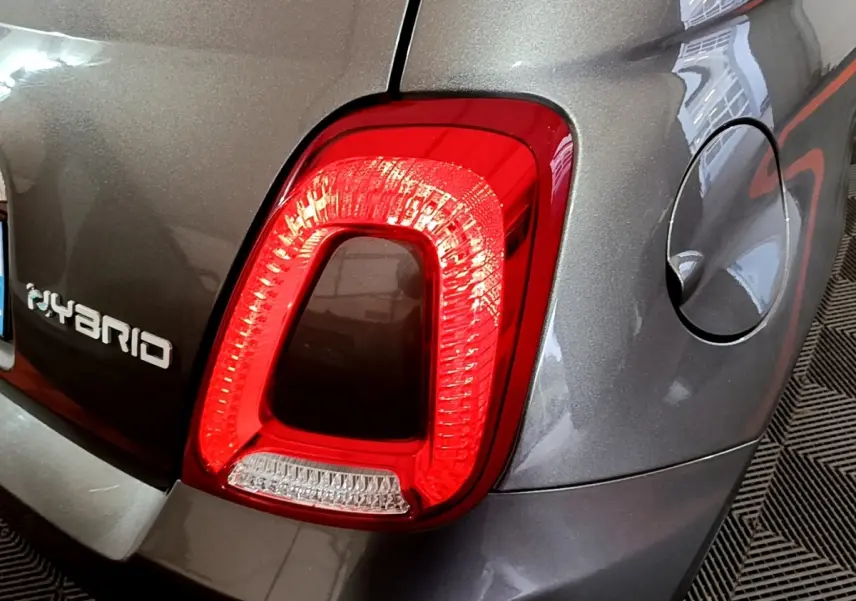Gros plan sur le feu arrière droit rouge d'une FIAT 500 hybride gris foncé avec logo Hybrid visible sur le coffre.