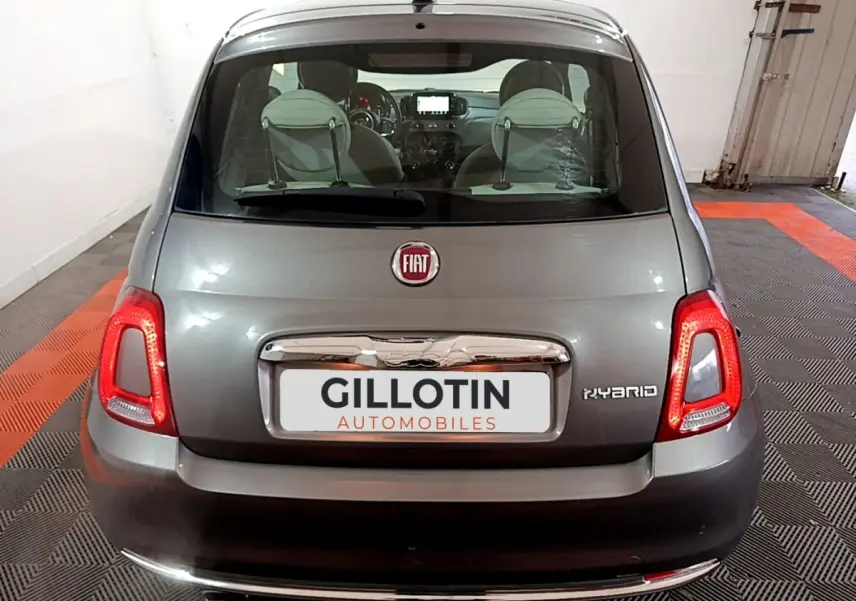 Vue arrière d'une FIAT 500 gris foncé hybride, avec feux LED allumés et logo FIAT visible sur le coffre.