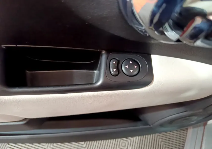 Détail des commandes de réglage des rétroviseurs sur la portière côté conducteur de la Fiat 500 gris foncé.