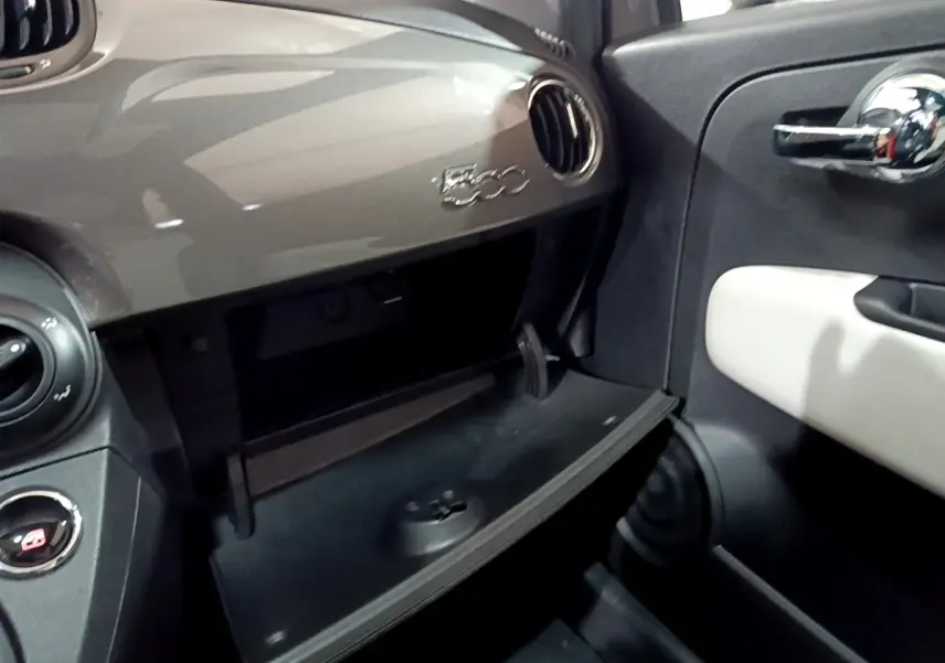 Vue intérieure côté passager du tableau de bord gris foncé avec boîte à gants ouverte et logo 500 visible.