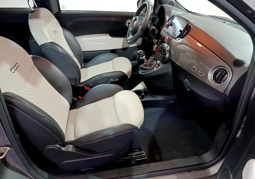 Vue intérieure côté conducteur de la Fiat 500 gris foncé, sièges bi-ton beige et noir avec logo 500 brodé.