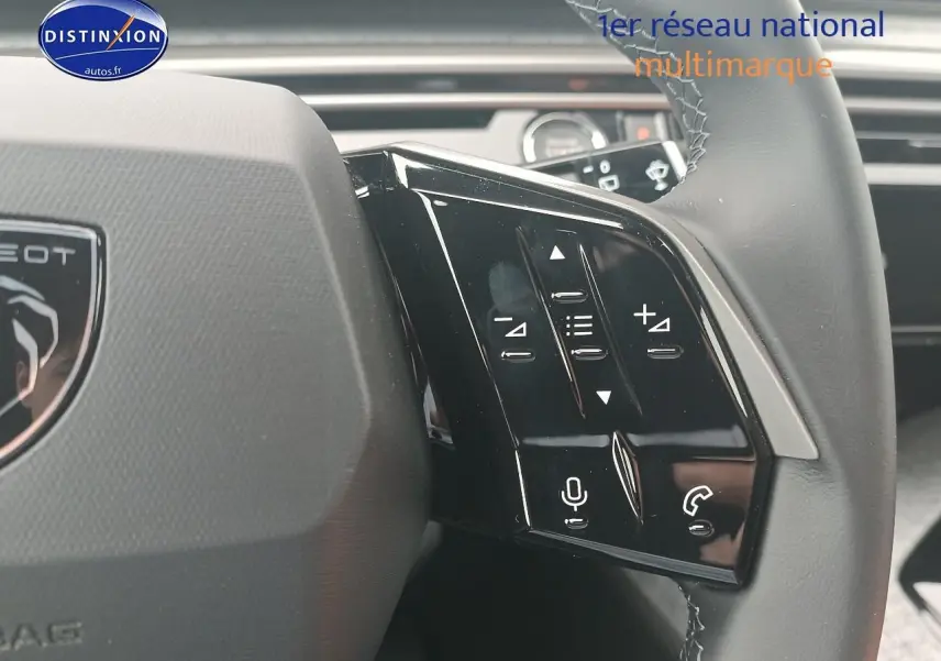 Gros plan sur les commandes vocales et audio au volant cuir du Peugeot 5008 Hybrid 145 allure gris Artense.