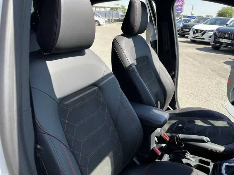 Vue intérieure des sièges avant en cuir noir avec surpiqûres rouges du Ford Puma blanc 2025, version 1.0 EcoBoost Hybrid ST-Line X.