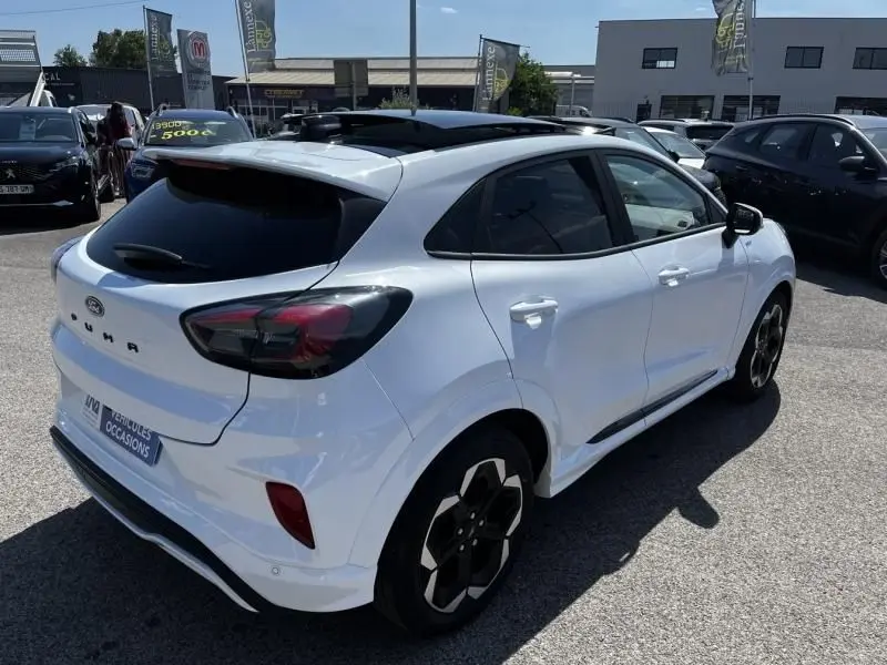 Vue 3/4 arrière droite d’un Ford Puma blanc 2025 avec toit panoramique et jantes noires distinctives.