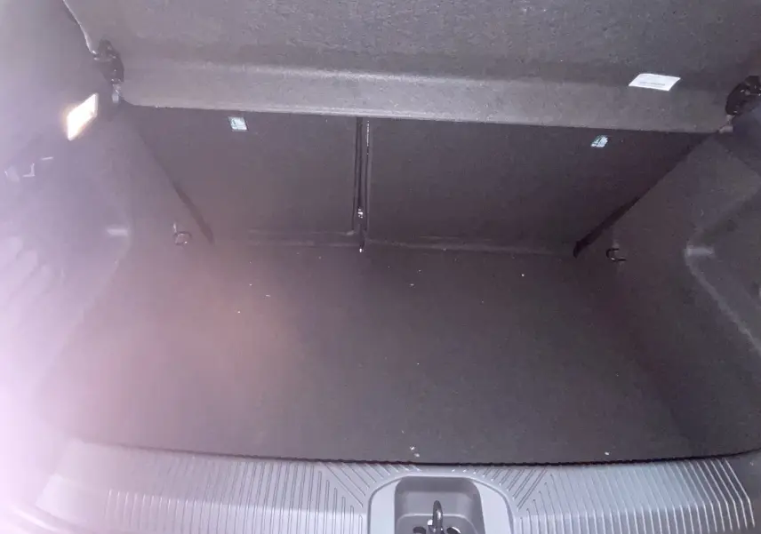 Coffre ouvert de la Renault Clio VI TCe 115ch Techno 2026, vue intérieure, revêtement noir et éclairage latéral.