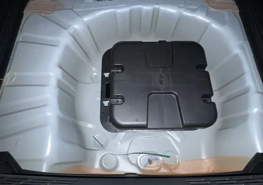 Coffre ouvert de Renault Clio VI TCe 115ch Techno 2026, vue plongeante sur espace gris Rafale métal sans roue de secours.