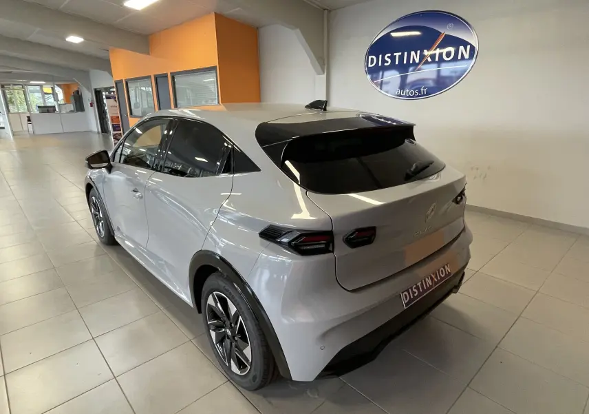 Vue 3/4 arrière droite d'une Renault Clio VI gris Rafale métal avec vitres teintées et jantes alliage en showroom.