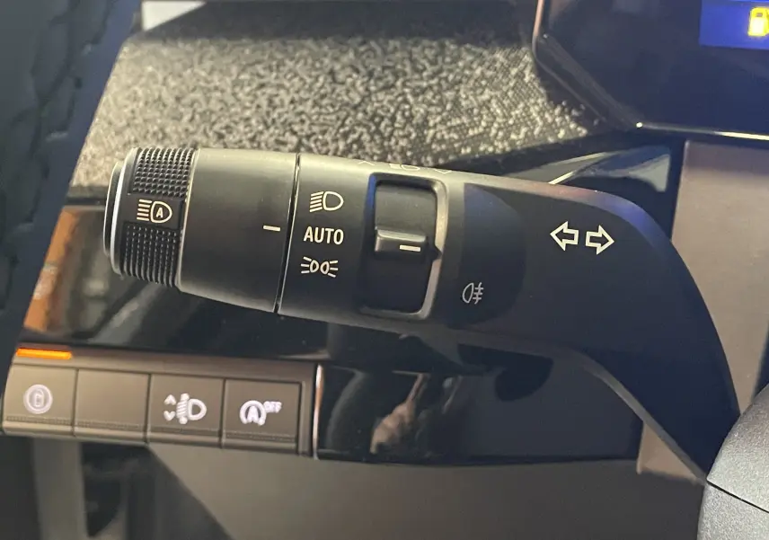Gros plan sur la commande des feux et clignotants dans l’habitacle noir de la Renault Clio VI TCe 115ch Techno.