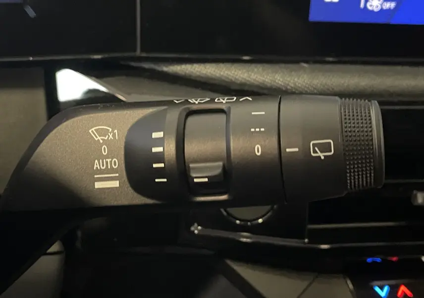 Gros plan sur la commande de l'essuie-glace intérieur d'une Renault Clio VI gris Rafale, avec réglages visibles.