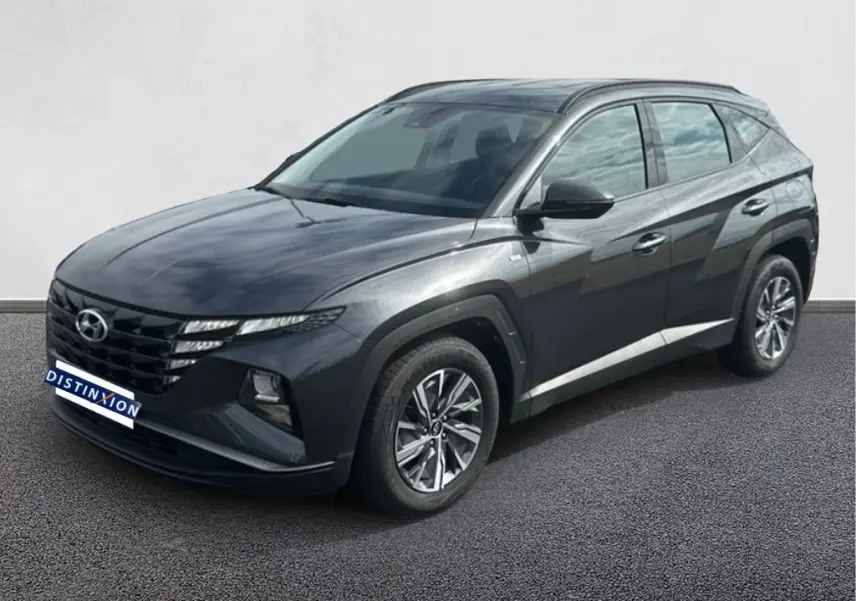 Hyundai Tucson gris 2023 en 3/4 avant droit, avec calandre distinctive et jantes alliage modernes.