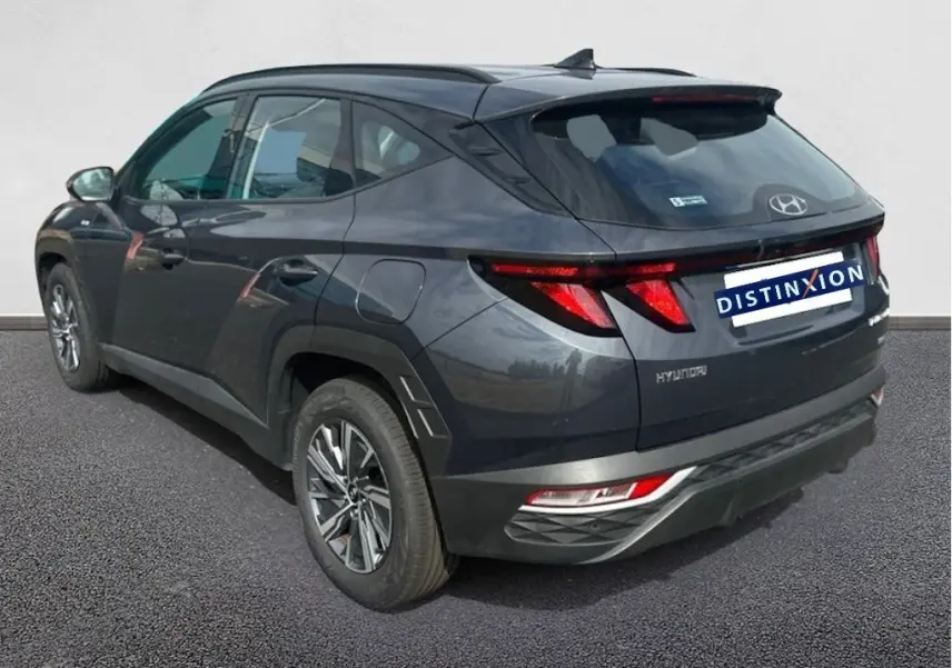 Vue 3/4 arrière droite du Hyundai Tucson gris 2023 avec feux arrière LED et jantes alliage distinctives.