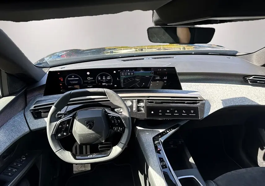 Vue intérieure avant du Peugeot 5008 Hybrid 145 GT 2025, volant cuir GT et tableau de bord numérique avec finition grise.