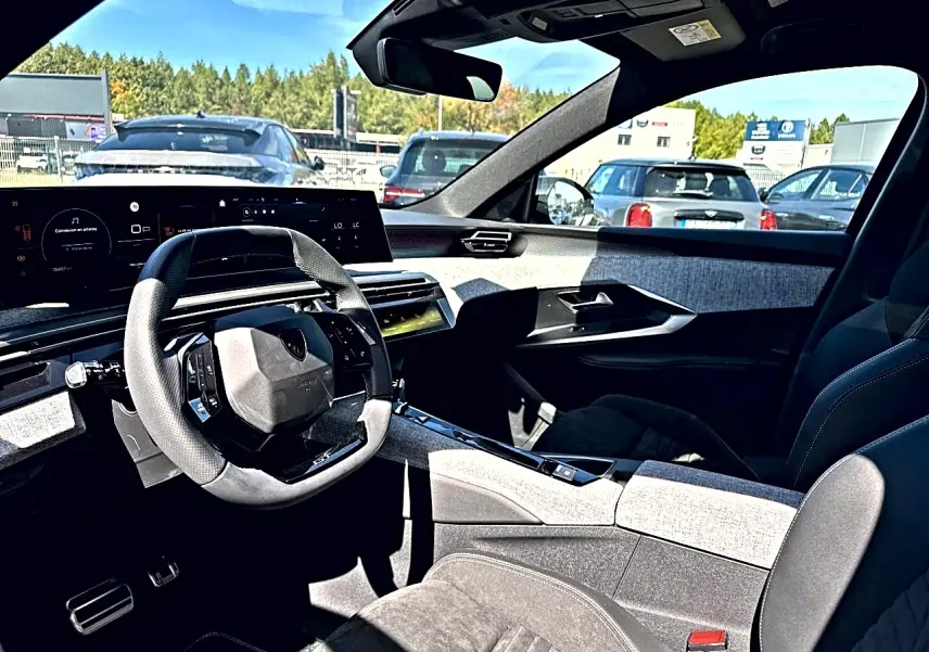 Intérieur du Peugeot 5008 Hybrid 145 GT 2025, vue côté conducteur, volant cuir et tableau de bord numérique.