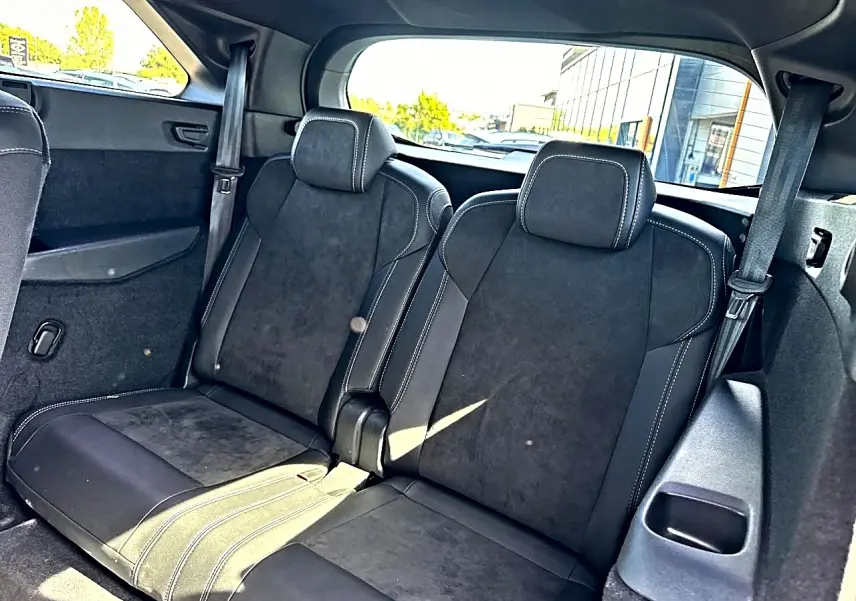 Vue intérieure sur les deux sièges arrière supplémentaires noirs avec surpiqûres blanches du Peugeot 5008 Hybrid 145 GT 2025.