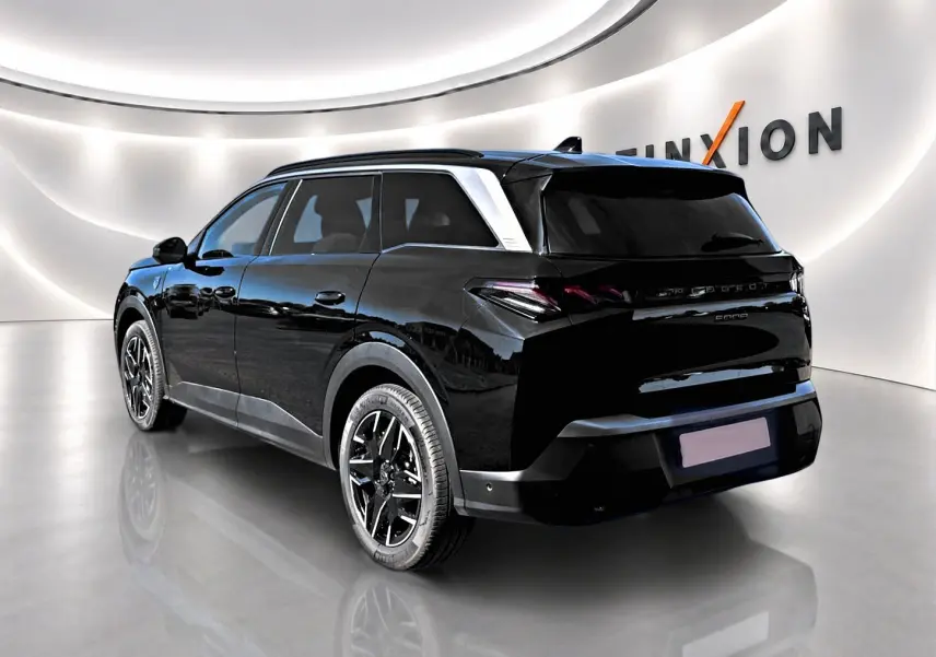 Peugeot 5008 Hybrid 145 GT noir en 3/4 arrière droit, avec jantes alliage et toit noir brillant dans un showroom lumineux.