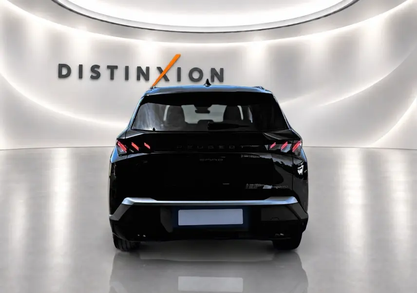 Vue arrière d'un Peugeot 5008 Hybrid 145 GT noir, avec feux arrière LED et becquet distinctif en showroom lumineux.