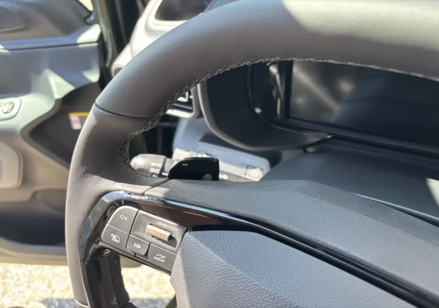 Gros plan sur le volant cuir multifonctions du Citroën Berlingo 2026, côté gauche, avec commandes intégrées.