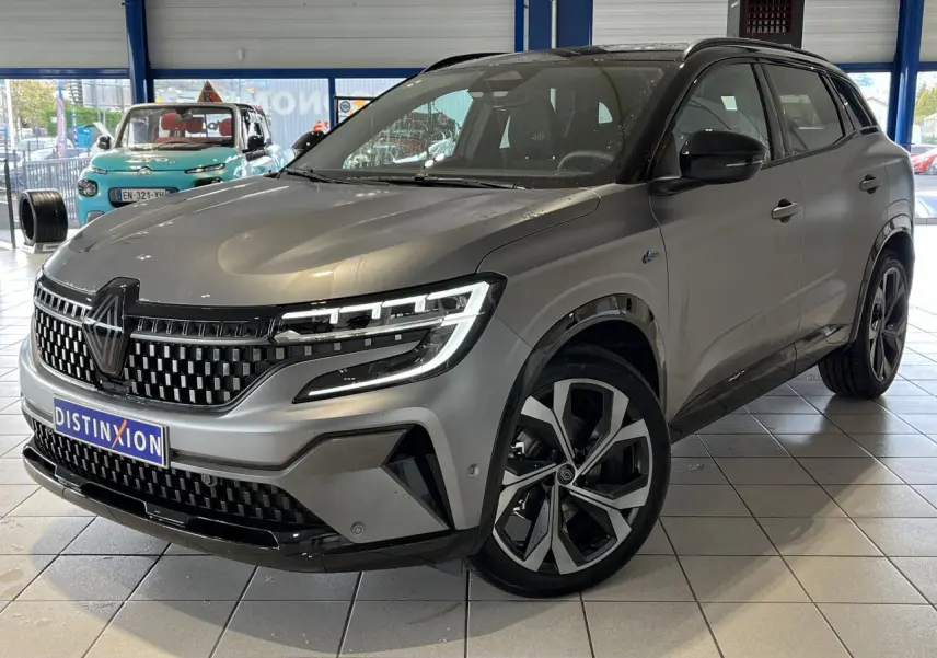 Renault Austral gris 3/4 avant droit en showroom, avec calandre damier ice black et jantes alliage 20 pouces.