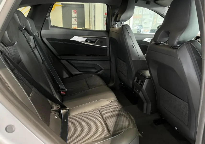 Vue intérieure côté gauche de la banquette arrière grise avec sellerie mixte tissu carbone Alcantara du Renault Austral 2025.