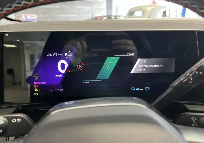 Tableau de bord numérique du Renault Austral 2025 affichant vitesse, mode Eco et alerte niveau carburant faible.