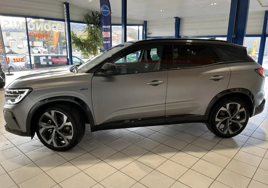 Renault Austral gris schiste vu de profil côté gauche, avec toit noir étoilé et jantes alliage 20 pouces.