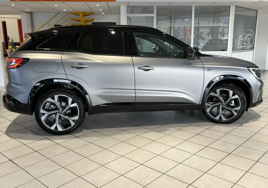 Vue de profil côté gauche d'un Renault Austral gris avec toit noir étoilé et jantes alliage 20 pouces diamantées.