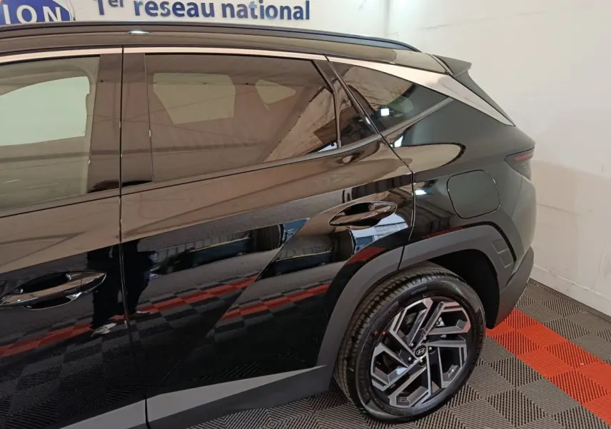 Vue côté droit arrière du Hyundai Tucson noir 2025 avec jantes alliage et lignes anguleuses marquées.