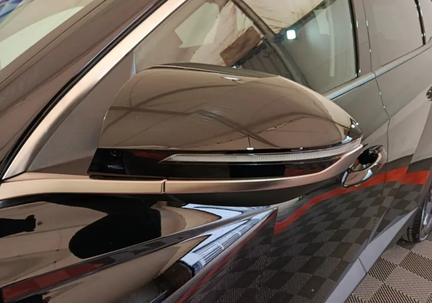Gros plan sur le rétroviseur droit noir brillant du Hyundai Tucson 1.6 Hybrid 239 Creative Auto 2025.