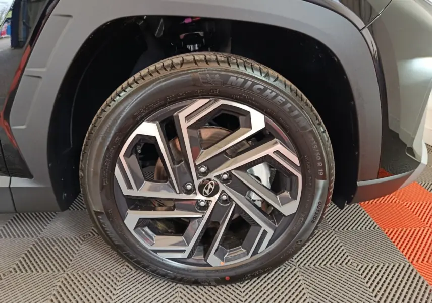 Gros plan sur la roue avant gauche noire du Hyundai Tucson 2025 avec jante alliage et pneu Michelin.