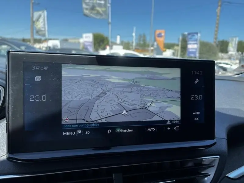 Écran tactile central du tableau de bord du Peugeot 3008 noir 2021, affichant la navigation GPS et la température intérieure.