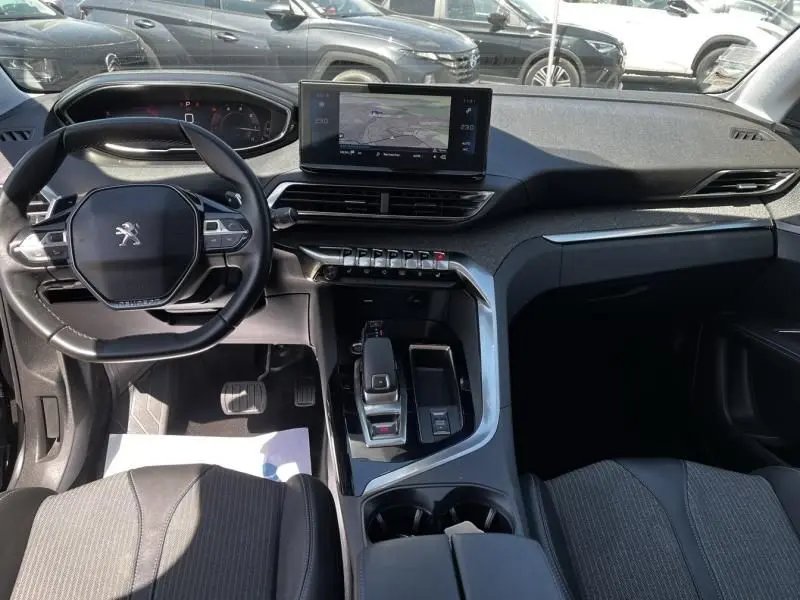 Vue intérieure du tableau de bord et console centrale du Peugeot 3008 noir 2021, avec écran tactile et volant compact.