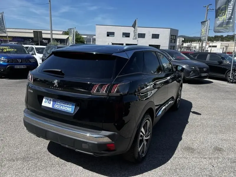 Peugeot 3008 noir vue 3/4 arrière droit, avec feux arrière à griffes et jantes alliage, stationné en extérieur.