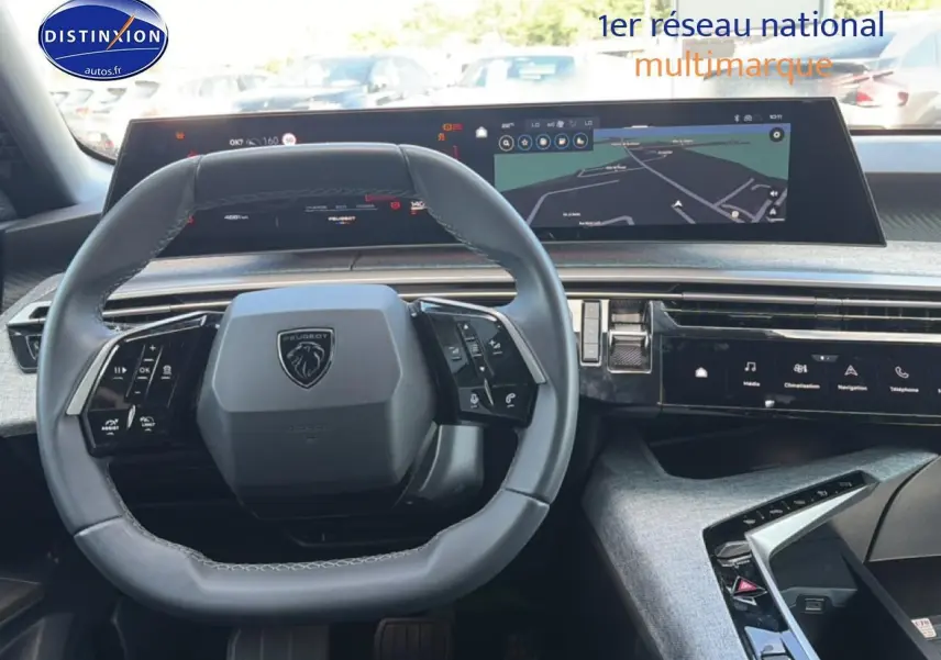 Vue intérieure du tableau de bord de la Peugeot 3008 hybride 2025, volant cuir multifonction et écran tactile large.