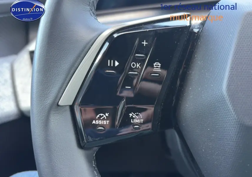 Gros plan sur les commandes multifonctions noires du volant cuir du Peugeot 3008 bleu 2025.